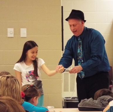 Scott entertains a nervous audience volunteer with magic.